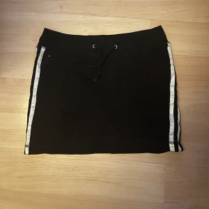 Svart kjol - Svart mjukis kjol med vita ränder på sidan storlek 34/36