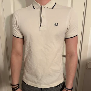 Vit FRED PERRY Polo T-shirt/Pikétröja - Stilren Vit FRED PERRY Polo Pikétröja 100%  Bomull i bra skick! Storlek XS men passar även som S. Modellen är 182 cm och väger 75 kg. Pris går ej att diskuteras!