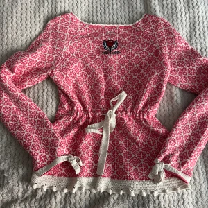 Odd Molly  - Odd Molly stickad tröja i vitt och rosa. Knytning med rosett baktill.  Fint skick. Storlek 2 vilket motsvara ca M/38. 