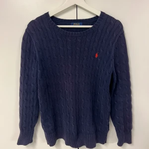 Stickad Ralph Lauren Tröja - Säjer denna fina kabelstickade raffe tröja som består av 💯% bomull. Jag skulle säga att den passar folk som är 182 och under. Hör gärna av er vid frågor. Skick 8/10, inga slitage💪😊 Nypris: 2299kr, Mitt pris: 399kr