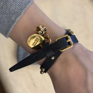 Alexander McQueen armband - Läderarmband från Alexander McQueen i väldigt gott skick. Går att justera till flera storlekar. Liten tillhörande smyckespåse följer med.