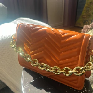 Orange axelremsväska  - Denna väska är väldigt fin inför sommaren. Man kan matcha sjuka outfits med denna. Färgen är elegant. Köpt från booho. Kom privat för prissänkning eller mer information 💋. Har använt ganska sällan.