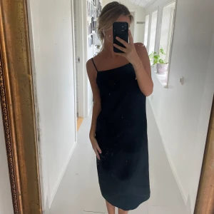 Klänning med slits - En fin svart långklänning från Weekday med slits baktil. Det är en väldigt rak modell.  Storlek XS. 