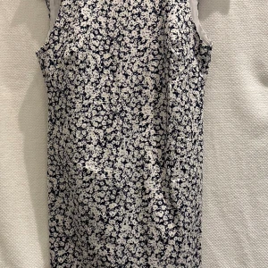 Blommig klänning från Zara - Blommig klänning från Zara Trafaluc.  V-ringad rygg med volang. Dragkedja i ryggen.   Strl. XS