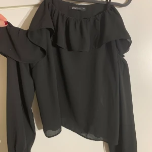 Svart topp - En svart topp med öppna axlar från Gina. Storlek 36. Knappt använd och inga tecken på användning. Pris kan diskuteras!