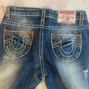 Low waist true religion jeans - Säljer mina true religion jeans i stl 28, men lite små i storleken skulle jag säga. Köpte på plick men har inte används så mycket eftersom knappen har gått sönder (se bild) (därför de är billiga). 