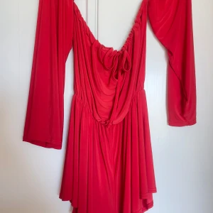 Röd jumpsuit  - Jättefin somrig röd jumpsuit från Nelly, väldigt skönt material och för att använda med ett par klackar eller till över bikinin till stranden.