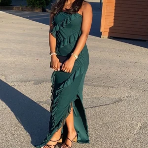 Grön fin klänning  - Säljer min älskade balklänning med volanger och slit vid vänstra benet💓 Skriv för mer info!