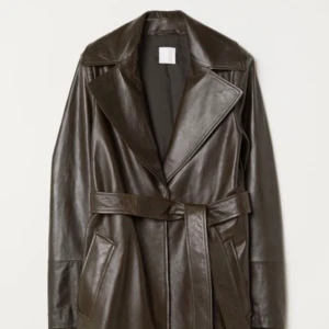 Kappa i läder - Brun/grön kappa i läder. Knäppas med både knappar och bälte. Normal i passformen.