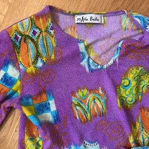 Nana Baila topp - Unik färgglad glittrig topp från ”Nana Baila Paris”. 🎨🪩✨ Så snyggt matcha denna med mörkblå jeans eller t.ex ljusblå kort kjol! 