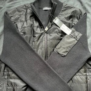 J.Lindeberg Cardigan  - Jag säljer denna feta Cardigan från J.lindeberg. Cardiganen är i storlek M och är aldrig använd förutom testad hemma. Köptes på nk och kvitto finns. Priset är inte hugget i sten. Vid minsta fundering eller fråga är det bara att skriva🤗