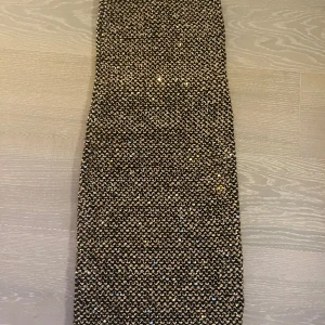 Glittrig axelbandslös klänning  - I fint skick, knappt använd.