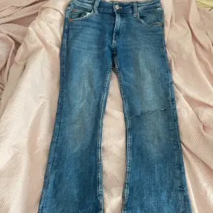 Säljer mina zara jeans som är lågmidjade och bootcut eftersom att dom inte passar längre dom är i en marinblå färg och har ett hål på höger sida men det är ett hål som ska finnas där och byxorna går inte att köpa längre. 
