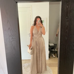 Balklänning i metallic champagne  - Balklänning använd en gång, den är köpt på bubbleroom och slutsåld