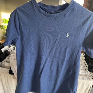 Blå Ralph lauren t-shirt - Blå Ralph lauren t-shirt i bra skick, säljer för den är för liten. Tröjan är i bra skick och priset kan diskuteras.