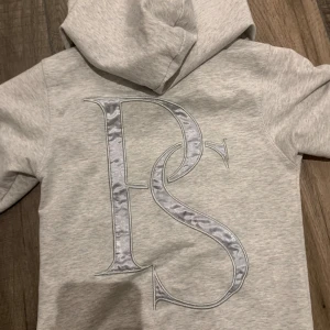 Pink of Sweden hoodie - En grå och silvrig Pink of Sweden hoodie i storlek xs. PS märke på ryggen i silkestyg och luvan i samma tyg och mönster, den har även en snygg detalj på dragkedjan och under fickan. I jättebra skick, inga slitningar eller hål💞