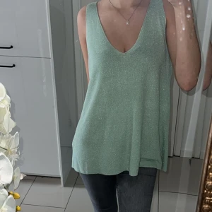 Glittrig turkos/grön linne  - Säljer denna då jag gått ner i vikt o den är lite stor  Väldigt bra skick användes 4 gånger bara  Passar S/M  Pris kan alltid diskuteras 