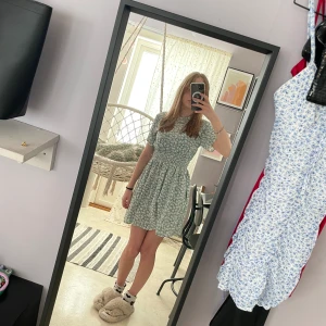 Grön kläning - Ny oanvänd kläning. Grön med vita blommor.