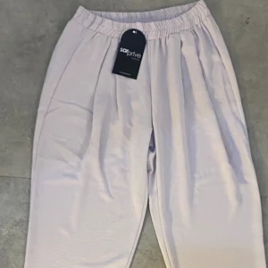 Tygbyxor- Dovrosa - Tygbyxor med raka ben och resår i färgen dovrosa. Aldrig använda och med prislapp säljer då de inte kommer till användning.