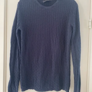 Marinblå stickad tröja från Anerkjendt i strl XL. - Marinblå stickad tröja från Anerkjendt i strl XL.  Använd men i fint begagnat skick.  Mått Över bröstet: ca 54 cm Längd från axeln och ner: ca 72 cm  100% bomull 