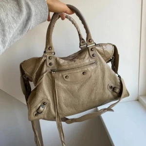 BALENCIAGA VÄSKA - SÄLJER min älskade Balenciaga city bag väska!! Väskan har några år på nacken men är fortfarande i gott skick med några tecken på slitage. Kvitto finns ej, men äkthetsbevis finns. Inga skambud. Äkta skinn. Fraktas/ hämtas i Täby. Skriv för mer info🤎