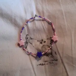Ett lila och rosa armband with tre stjärnor.