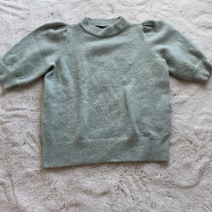 Stickad T-shirt  - Fin svag grön färg. Lite små nopprig därav priset