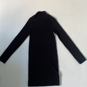Svart stickad klänning - Svart ribbad Stickad klänning  Väldigt skönt material  Lite polo  Storlek m