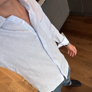 Ljusblå linneskjorta - Ljusblå randig linneskjorta från Massimo dutti. Mycket bra skick  Storlek S