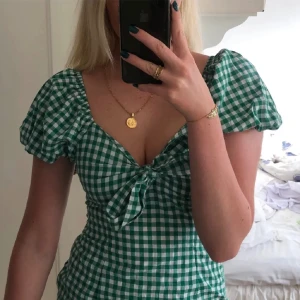 Sommarklänning  - Miniklänning i grön rutigt mönster. I nyskick. Går att knyta vid brösten, klänningen knäpps med dragkedja 💚 