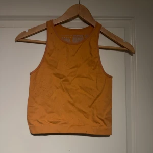 Träningslinne  - Aprikosfärgat träningstopp, använd och lite nopprig efter tvättad men annars fint skick. Mer aprikosfärgad än orange som bilder visar