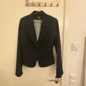 Kavaj - Snygg kavaj som är aningen ribbad i materialet. Har små kuddar i axlarna. 