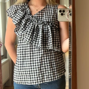 Mango topp - Rutig topp från mango med en volang. Storlek M men passar för mig som brukar ha S. 