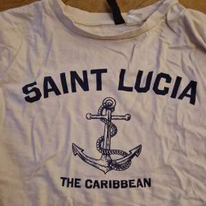 Säljer en beige magtröja från Divided med ett coolt Saint Lucia-tryck och ett ankare på framsidan. den  är i storlek XS och är perfekt för sommaren. Perfekt för en avslappnad look!