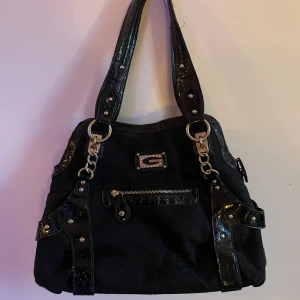 Väska  - Jättefin väska från gussaci 3 fickor i väskan, därav en stängs med dragkedja Defekter- lite nopprig här & var men inget som syns. Finns även hund i hemmet men tar bort det mesta jag kan innan den skickas!  Se mer ( bild 3 ) lite slitage på banden.   