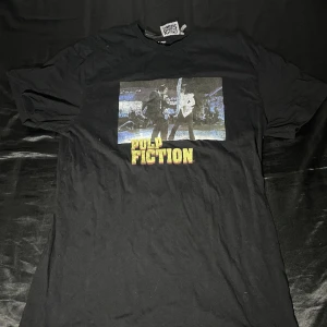 Pulp fiction graphic tee  - Pulp fiction t-shirt, i storlek S/M, använd hyfsat många gånger fast inga stora tecken.