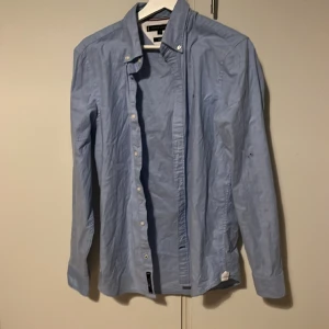 Tommy hilfiger - Hejsan, säljer denna skjorta för den är för liten för mig. Bara använd en gång då jag köpte den inför ett bröllop och att den bara vart använd en gång. Ny pris 899 mitt pris  250  Tveka inte på att ställa frågor. 