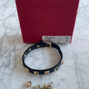 Valentino Armband  - Ett svart valentino med guldiga nitar.  Kvalitet 10/10. Extranitar ingår men ingen dustbag. Levererar samma dag någon köper det. Köpt från valentino. 