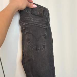 Levis jeans, mörk gråa, utvättad stil. Storlek 24 i midja, går ner till anklarna på mig som är 167 cm. Lågmidjad 