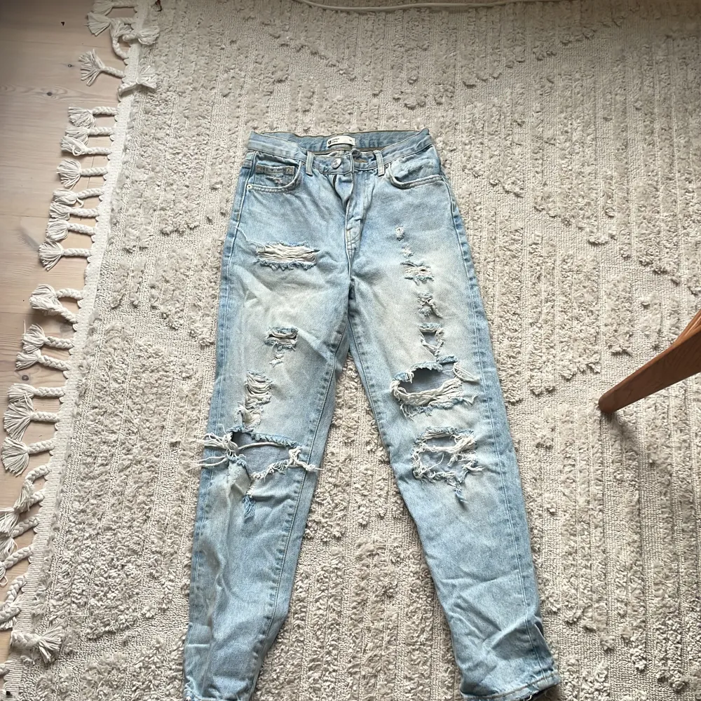 Ljusblåa jeans från Gina tricot med hål på. Västligt snygga jeans i storlek 34. Dom är väl använda men det syns kannapt 🫶🏼. Jeans & Byxor.
