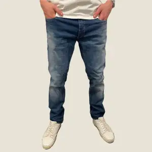 Riktigt snygga jeans från Jack and Jones  i tvättad mörkblå färg. Jeansen är använda men i fint skick. Storlek 33/32. Modellen på bilden är 187cm. Ställ gärna frågor vid funderingar!