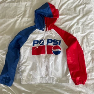 Vindjacka Pepsi - Tunn vindjacka från Pepsi i retro-stil. Jackan är använd max 2ggr och är i superfint skick. Jackan är i storlek M.