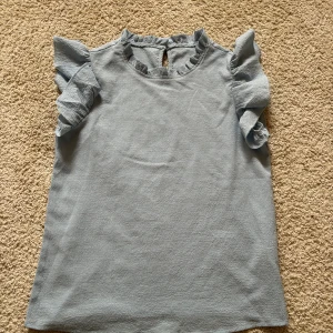 Blå blus -  Denna blus är i mycket bra skick och nästan aldrig använd. Den är lite större i storleken.