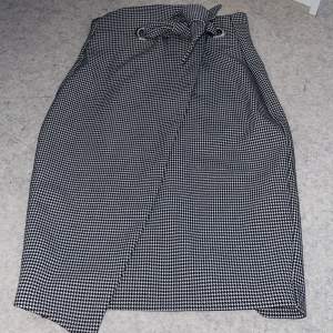 Svartvit kjol från H&M i storlek 34, inga defekter ser ny ut. Använd fåtal gånger, den är högmidjad och går ner till knäna