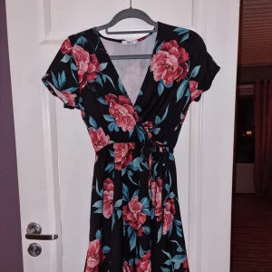 Klänning  - Mörk blommiga klänning från Hailys. 