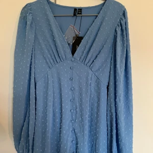 Blå sommarklänning - En blå härlig sommarklänning som liknar Adoore klänningarna i modellen. Från Veromoda. V-ringad, knappar och med stretch.  Aldrig använd så lapparna sitter kvar, passar inte mig tyvärr, men den är sååå fin!  I stl S.  