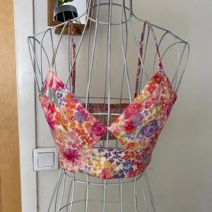 Blommig linne croppad - Superbra skick,  aldrig använd. Justerbara axelband. Stretchig vid ryggen för lättare anpassning efter kropp 