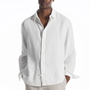 Vit Linneskjorta från COS (Oanvänd) - Oanvänd. Har bara testat den och insåg att den var lite stor för mig. Storlek S i relaxed fit. Riktigt snyggt plagg från COS.   Nypris 900kr