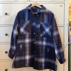 Mjuk blå rutig jacka  - Jättebra skick, knappt använd  Stor i storleken  90% polyester 5% akryl 2% ull 1% bomull 1% polyamid 1% viskos