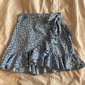 Blå kjol - Söt blå omlottkjol från shein. Den är i bra skick och inte använd så mycket. Normal i storleken.
